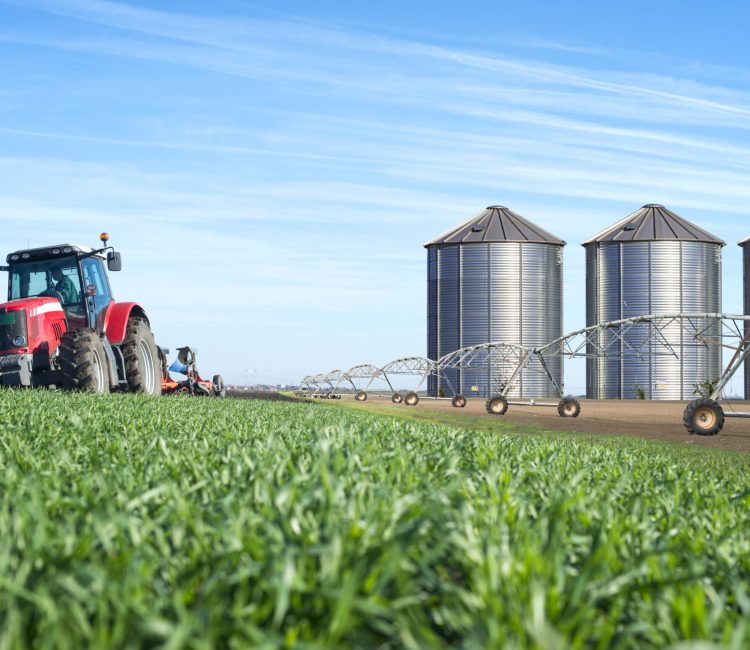 Agriculture and food production concept with tractor machine silos and irrigation system. Agriculture and food production concept with tractor machine silos and irrigation system.